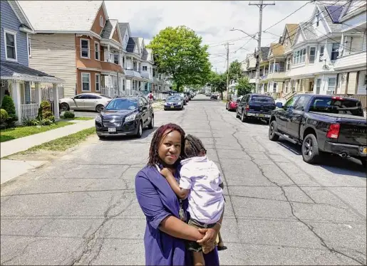  ?? Photos by Paul Buckowski / Times Union ?? Ifrecak Miller holds her son Osaze Edwards, 3, as she stands down the street from her home on Lincoln Avenue in Schenectad­y. “We want [the city] to partner with us, not penalize us,” Miller said.