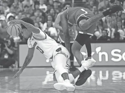  ?? MARK HOFFMAN / MILWAUKEE JOURNAL SENTINEL ?? Maryland guard DeShawn Harris-Smith fouls Wisconsin guard Chucky Hepburn during the first half Tuesday at the Kohl Center in Madison. Hepburn had 11 points and four rebounds.