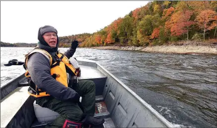  ?? NWA Democrat-Gazette/FLIP PUTTHOFF ?? Joe Neal admires a bluff at Beaver Lake during a boat trip to look for loons in late October. Loons sing a mesmerizin­g song during late fall and winter.