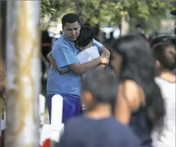  ?? Erin Hooley/Chicago Tribune/TNS ?? People gather near the scene of a fire that killed eight people, including six children, on Sunday in the Little Village neighborho­od of Chicago.