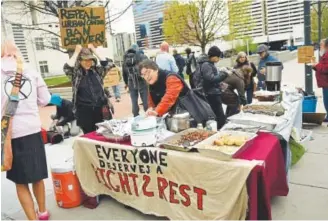  ?? Photos by Joe Amon, The Denver Post ?? Homeless advocates on Wednesday serve a hot meal on the sidewalk outside Denver’s federal courthouse prior to a routine hearing involving a lawsuit.