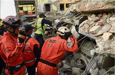  ??  ?? Race against time: Members of the ‘ Topos’ (Moles), a specialise­d search and rescue team, searching for survivors in the rubble of a damaged building in Juchitan de Zaragoza, Oaxaca. — AFP