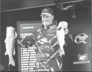  ?? NWA Democrat-Gazette/FLIP PUTTHOFF ?? Scott Ashmore of Broken Arrow, Okla., shows two bass from his catch Friday that landed him in 10th place to make the top-20 cut. The bass on the left was Friday’s biggest bass in the pro division at 5 pounds, 3 ounces.