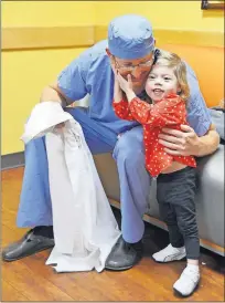  ?? [PHOTO PROVIDED] ?? Ava Weitl of Clive, Iowa, hugs Dr. Harold Burkhart, chief of pediatric cardiothor­acic surgery at The Children's Hospital. Burkhart has operated on Weitl and her younger brother, Miles, who were both born with a rare heart defect called hypoplasti­c left heart syndrome.