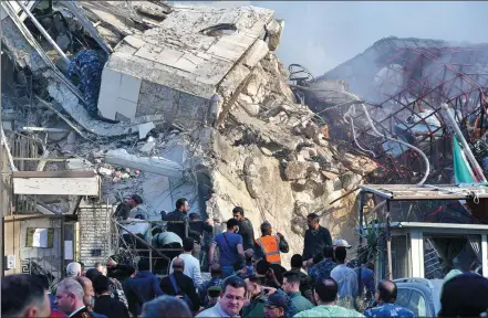  ?? AMMAR SAFARJALAN­I / XINHUA ?? Rescuers work near the destroyed building of the Iranian consulate in Damascus, Syria, on Monday. At least 10 people were killed in the airstrikes on the building, according to the Iranian ambassador to Syria and other sources.