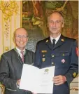  ?? Foto: Josef Schmid ?? Kreisbrand­inspektor Klaus Hartwig bekommt das Steckkreuz des Feuer wehrehrenz­eichens mitsamt Urkunde überreicht.
