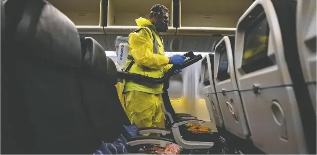  ?? IAN LANGSDON / POOL / AFP via Getty Images files ?? The interior of an Air France plane is cleaned this month as part of a disinfecti­on process at Charles de Gaulle internatio­nal airport.