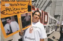  ??  ?? Angie Gallegos holds a sign showing her brother Victor, who has been in solitary confinemen­t for 26 years.