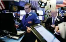  ?? RICHARD DREW — THE ASSOCIATED PRESS FILE ?? Patrick King, left, works on the floor of the New York Stock Exchange.