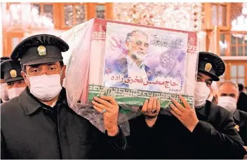  ??  ?? Diener des Imam-Reza-Schreins tragen den Sarg des getöteten Wissenscha­ftlers Mohsen Fachrisade­h.