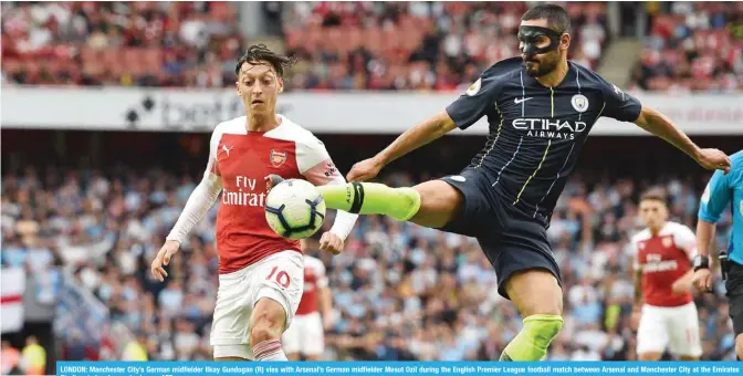  ??  ?? LONDON: Manchester City’s German midfielder Ilkay Gundogan (R) vies with Arsenal’s German midfielder Mesut Ozil during the English Premier League football match between Arsenal and Manchester City at the Emirates Stadium in London yesterday. — AFP