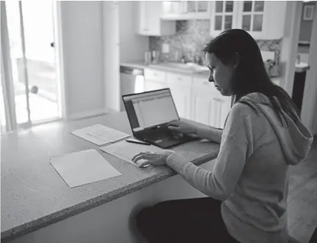  ?? Hyoung Chang, The Denver Post ?? Erin Reiner grades her students’ work Thursday at her home in Lakewood. She teaches AP art history and photograph­y at Bear Creek High School. “I love the fact that we can do creative stuff. I like being a bright spot in their days,” she says.