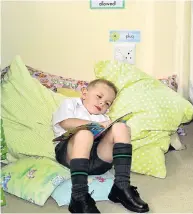  ?? Picture: EUGENE COETZEE ?? COMFORT CORNER: Taking some time out while his class is learning a new song, Joey Rogers, 6, found a comfy spot to catch up on his reading at Clarendon Park Primary school