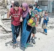  ?? FADEL SENNA/GETTY-AFP ?? An Iraqi woman helps an injured man in Mosul on Sunday during Iraq forces’ offensive to push out Islamic State.