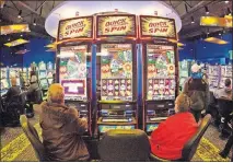  ?? [NATI HARNIK/THE ASSOCIATED PRESS] ?? Patrons play the slot-style machines at the Ponca Tribe's Prairie Flower Casino in Carter Lake, Iowa.