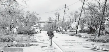  ?? BRENDAN SMIALOWSKI/GETTY-AFP ?? A man walks down the street after Hurricane Michael made landfall on Wednesday in Panama City.