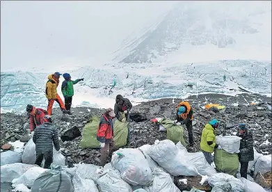  ?? NGAKWANG TASHI / XINHUA ?? Volunteers sort garbage on the north slope of Qomolangma in the Tibet autonomous region on Monday.