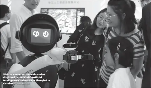  ??  ?? Visitors communicat­e with a robot displayed in the World Artificial Intelligen­ce Conference in Shanghai in October.