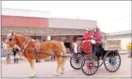  ?? RACHEL DICKERSON/MCDONALD COUNTY PRESS ?? Georgia Henderson and Christina Mackey of Memories with Gabby ride their horse-drawn carriage in the Goodman Christmas parade.