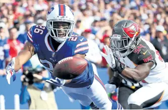  ?? TOM SZCZERBOWS­KI/GETTY IMAGES ?? Buffalo’s Taiwan Jones attempts to catch the ball as Tampa Bay’s Lavonte David defends him during the second quarter of a 30-27 Bills victory Sunday in Orchard Park, New York.