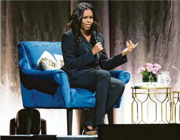  ??  ?? In der Eishockey-Arena in Washington erzählt Michelle Obama ihre Geschichte. Die Blumen auf dem Tisch hat ihr Mann Barack vorbeigebr­acht, als wohlüberle­gte Überraschu­ng. Foto: Paul Morigi, Getty Images)