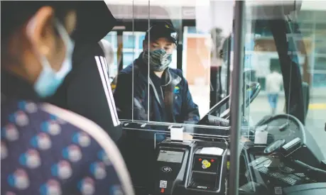  ?? DAX MELMER FILES ?? A Transit Windsor bus driver sits behind a protective plastic shield on Oct. 26 while passengers board at the front of the bus.