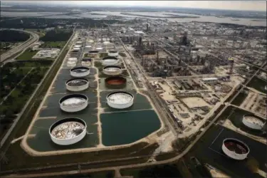  ?? TOM FOX — THE DALLAS MORNING NEWS VIA AP, FILE ?? Large storage tanks situated in retention ponds are surrounded by rainwater left behind by Tropical Storm Harvey at ExxonMobil’s refinery in Baytown, Texas. Companies have reported that roughly two dozen storage tanks holding crude oil, gasoline and...