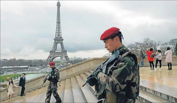  ?? PHILIPPE WOJAZER / REUTERS ?? Dos paracaidis­tas patrulland­o por los alrededore­s de la torre Eiffel, en París, donde el despliegue de seguridad se mantiene reforzado