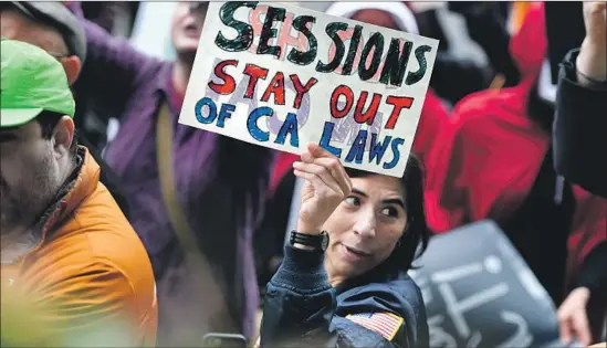  ?? Josh Edelson For The Times ?? A DEMONSTRAT­OR displays a message for U.S. Atty. Gen. Jeff Sessions, who called California’s immigratio­n policies “irrational, unfair and unconstitu­tional.”