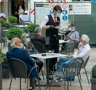  ?? (Ansa-Pretto) ?? In città Un bar di Trento in funzione fino alle 18 con alcuni avventori ai tavoli