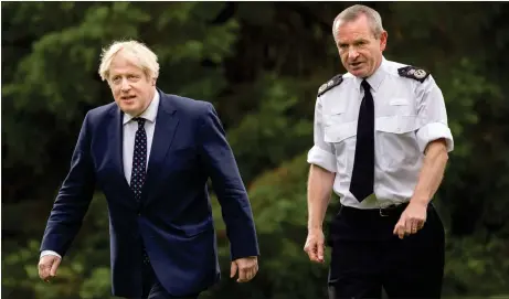  ?? Picture: James Glossop ?? Boris Johnson strides out with Chief Constable Iain Livingston­e during a visit to the Scottish Police College at Tulliallan near Kincardine, Fife. The Prime Minister promised ‘all the money that is needed’ will be given to fund the thousands of officers required for the COP26 summit Glasgow later this year