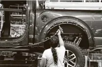  ?? Carlos Osorio / Associated Press ?? A United Auto Workers assemblyma­n works on a 2018 Ford F-150 truck being assembled in Dearborn, Mich.