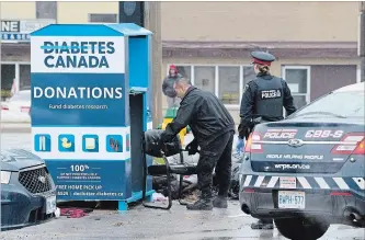  ?? MATHEW MCCARTHY WATERLOO REGION RECORD ?? Police investigat­e after a body was found in a donation bin in Cambridge on Thursday.