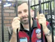  ?? ALISON LANGLEY/NIAGARA FALLS REVIEW ?? Christian Nelson sits in cell at Lowe's on McLeod Road, Saturday. The store manager was in “jail” for much to mark the launch of Lowe's Canada Heroes program in support of Heartland Forest.
