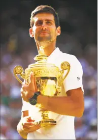  ?? Clive Brunskill / Getty Images ?? Novak Djokovic celebrates with the trophy after winning the men's singles final at Wimbledon on Sunday.