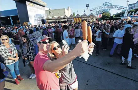  ??  ?? Fletcher's corny dogs are photogenic and a rite of passage for OU and Texas fans every October at the State Fair of Texas outside Cotton Bowl Stadium in Dallas with nearly half a million sold each fall. [AP PHOTO/LM OTERO]