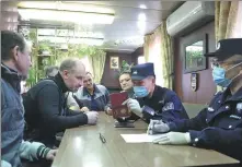  ?? PHOTOS BY ZOU HONG / CHINA DAILY Kopcakob, ?? Police officers Fu Yunlong (front) and Xu Jinzhen from the entry and exit frontier inspection station in Dalian, Liaoning province, board a Liberian container vessel for an inspection at a port on Feb 15. Officers Zhang Sheng (second from right) and Zhang Xin from the station’s second team talk with crew members during an inspection on a Russian long-distance seafood cargo vessel, on Feb 13. Officers pose with the foreign seamen with Chinese New Year decoration­s at a port on Feb 13.