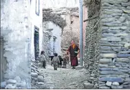  ?? PRAKASH MATHEMA / AGENCE FRANCE-PRESSE ?? A Buddhist monk walks past children in Ghemi Village in Upper Mustang, northwest of Kathmandu, Nepal, in June.