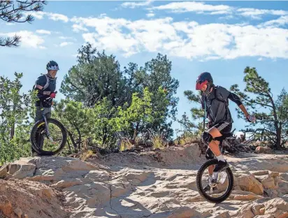  ?? PARKER SEIBOLD/THE GAZETTE VIA AP ?? Rob Urban coaches his son, Zane Urban, through a line on his mountain unicycle at Ute Valley Park in Colorado Springs, Colo. “There’s more unicyclist­s than you think, but as far as people riding on rough terrain, it’s a pretty small universe,” Rob Urban says. And, he adds, “There’s a lot of falling involved.”