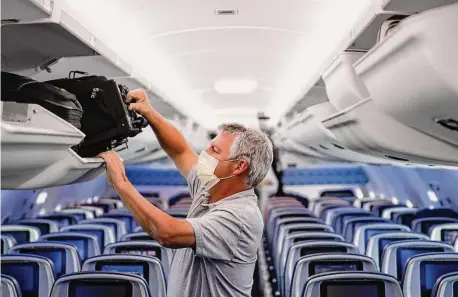  ?? John Minchillo / Associated Press file photo ?? A passenger wears personal protective equipment on May 28, 2020, after landing in Minneapoli­s on a Delta Airlines flight. The European Union Aviation Safety Agency said Wednesday that from next week onward it is no longer recommendi­ng masks.