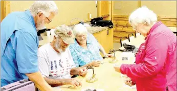  ?? Keith Bryant/The Weekly Vista ?? Mike Swanner, left, helps Jay and Karen Allred make fly-fishing lures while Beth Arnold provides instructio­ns.