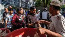  ?? ?? People take bubur lambuk for breaking fast, distribute­d by Masjid Jamek Kampung Baru.