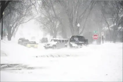  ?? ERIN WOODIEL /THE ARGUS LEADER ?? VEHICLES ARE STUCK DURING A SNOWSTORM on Wednesday in Sioux Falls, S.D. A brutal winter storm knocked out power in California, closed interstate highways from Arizona to Wyoming and prompted more than 1,200 flight cancellati­ons Wednesday – and the worst won’t be over for several days.