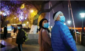  ??  ?? Almost a year after the global outbreak of the coronaviru­s disease in Wuhan a couple walk through the city Photograph: Aly Song/Reuters