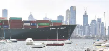  ??  ?? A container ship passes leisure boats as it leaves the Port of Melbourne. — AFP photo