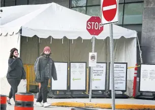  ?? ANDREW FRANCIS WALLACE TORONTO STAR ?? People walk past a COVID assessment centre at Women’s College Hospital on Monday. Data seen by the Star shows about two-thirds of the city has a test-positivity rate of higher than three per cent, considered a critical level by public health authoritie­s in Toronto and beyond.