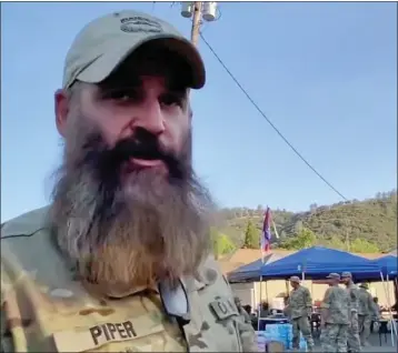  ?? FRAME FROM VIDEO BY ROBERT KUWADA — FRESNO BEE ?? Piper Brown, “major” from the California State Militia Echo company, talks about helping support the Mariposa community as the Oak Fire burns close by, forcing many evacuation­s in the county.