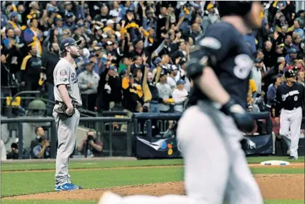  ?? Photograph­s by Wally Skalij Los Angeles Times ?? CLAYTON KERSHAW CAN’T believe it after giving up a home run to Milwaukee reliever Brandon Woodruff in the third inning.