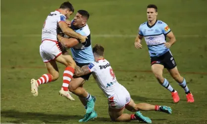  ??  ?? Braden Hamlin-Uele of the Sharks is tackled by Ben Hunt of the Dragons and Cameron McInnes of the Dragons during the round five NRL match between the St George Illawarra Dragons and the Cronulla Sharks at Campbellto­wn Stadium. Photograph: Jason McCawley/Getty Images