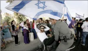  ?? AP/SEBASTIAN SCHEINER ?? A man tussles with police Friday in Jerusalem as a crowd protests over the slayings Thursday of a Jewish settler couple in the West Bank.